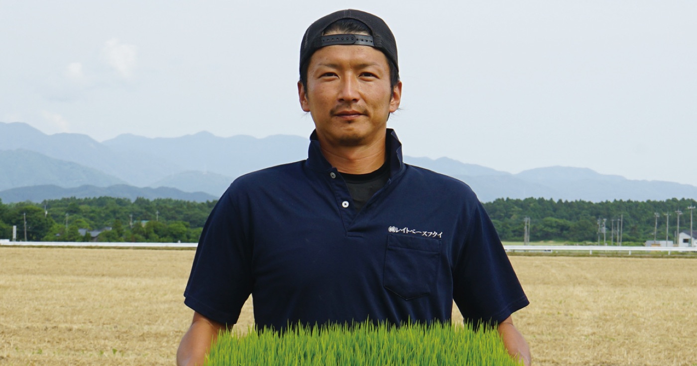苗を抱えて立つ生産者